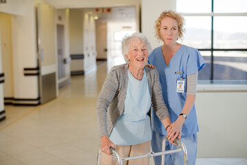 Fototapeta premium Nurse helping senior patient with walker in hospital corridor