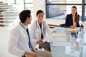Doctors and businesswoman talking in meeting