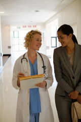 Obraz premium Doctor and businesswoman walking in hospital corridor