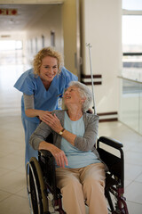 Portrait of smiling nurse and elderly patient in wheelchair