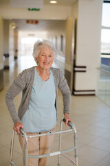 Senior patient using walker in hospital