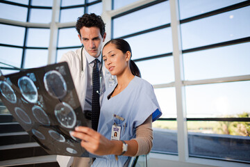 Fototapeta na wymiar Doctor and nurse viewing head x-rays on hospital staircase