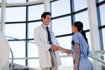 Obraz premium Doctor and nurse handshaking on hospital staircase