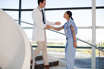 Obraz premium Doctor and nurse handshaking on hospital staircase