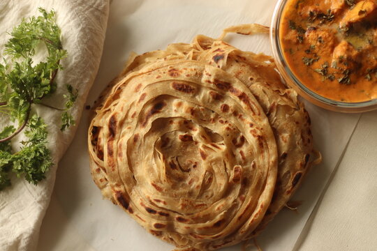 Parotta or Porotta, a layered flatbread made of Maida. This flaky ribbon pancake is a favourite of Kerala. Shot with Butter chicken