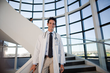 Portrait of smiling doctor on staircase in hospital