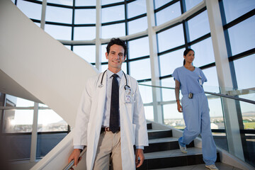 Portrait of smiling doctor on staircase in hospital