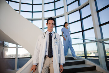 Portrait of smiling doctor on staircase in hospital