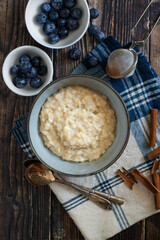 Oatmeal or porridge, for breakfast. Wooden background