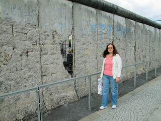 A Woman Standing Next ro the Remains of the Berlin Wall in Germany the Once Separated Germany with an Iron Curtain