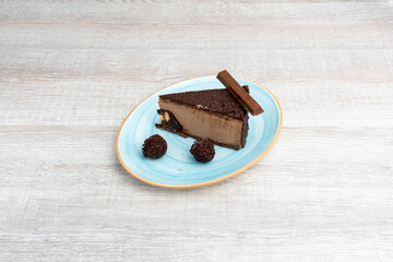 chocolate cake with crunchy bar and chocolate truffles on light wooden table
