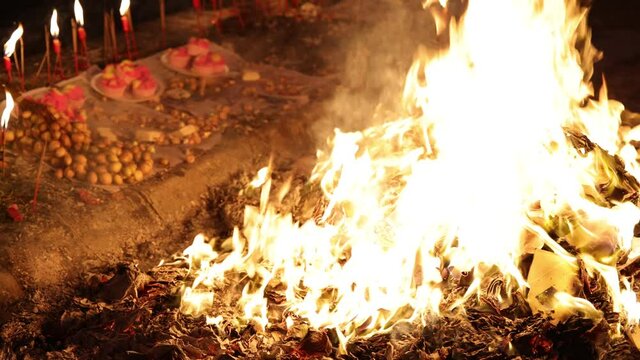 Chinese hungry ghost festival burning flame fire glowing ashes firefly colourful variety prayer paper joss money fake currency joss stick mini fag food fruit offering