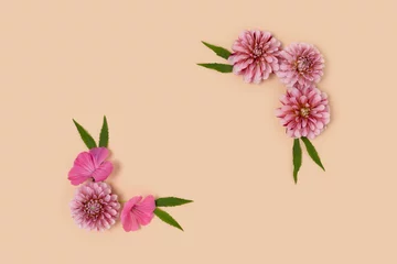 Deurstickers Flower border frame made of pink dahlia and green leaves on a beige background. Springtime concept with copyspace. © rorygezfresh