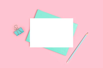 Blank paper card mockup and stationery on a pink background. Minimalistic school workspace.