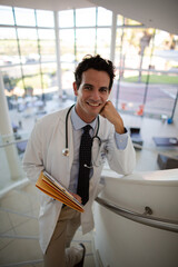 Portrait of smiling doctor on stairs in hospital