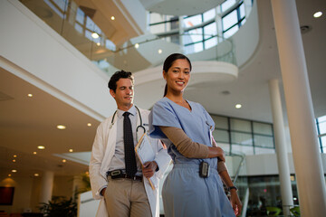 Portrait of smiling doctor and nurse in hospital atrium