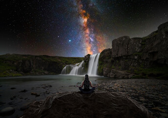 Woman doing yoga in front of a magic waterfall