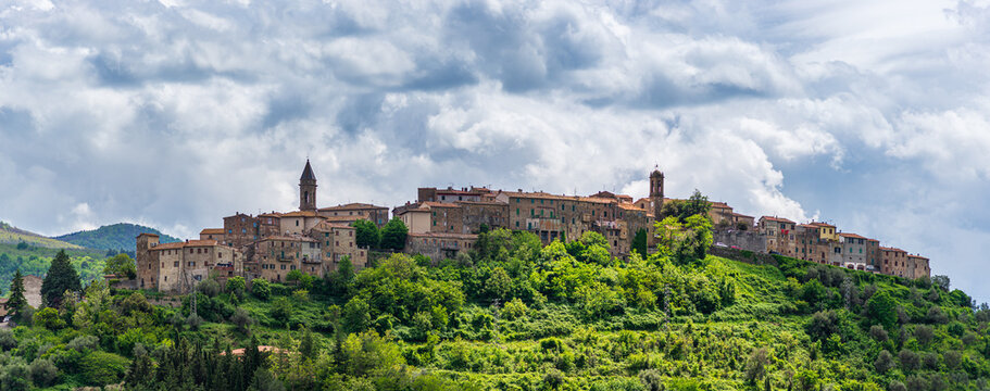 Seggiano, a medieval village and fortress in Monte Amiata region, Tuscany, Italy. The stone buildings perched on hill top and rock cliff against dramatic sky.
