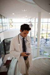 Doctor using phone on hospital staircase