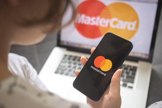 Kharkov, Ukraine - August 25, 2021: Woman using Mastercard application and holding smartphone