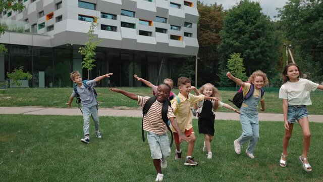 Cheerful multiracial children taking fun on schoolyard