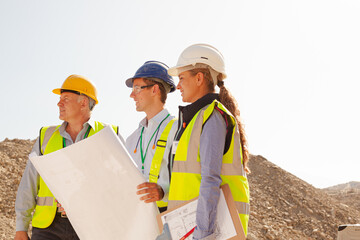 Business people and workers talking in quarry