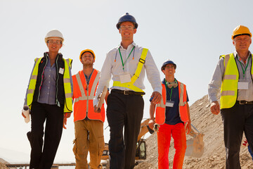 Businessman in hard hat smiling in quarry