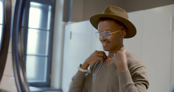 Afro-american man getting dressed in public restroom with mirror