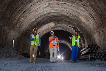 Businessmen reading blueprints in quarry