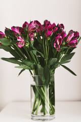 Alstroemeria flowers bouquet in a transparent vase. Simple home decor idea. Fresh flowers for room decoration