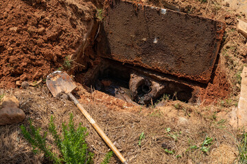 Septic tank with lid excavated and open to show sewage sludge, horizontal aspect