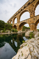 Low angle view of a Roman Empire aqueduct, Pont du Gard in France. Ancient civilisation engineering...
