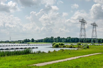 Zwolle, The Netherlands, August 4, 2021: artificial lake Sekdoornse Plas created for gravel extraction with a large number of floating solar panels - obrazy, fototapety, plakaty