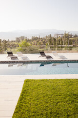Fototapeta na wymiar Luxury lap pool with tree and mountains in background