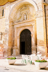 Coffee shop terrace in front of a church in a small town of Spain during summer holiday.
