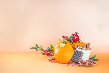 Autumn composition, Thanksgiving holiday greeting card. Pumpkin cooking background, with fall festive decor, small pumpkins, spices, pecan nuts, 