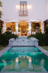 Obraz na płótnie Canvas Luxury swimming pool and villa illuminated at night
