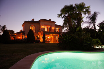 Luxury swimming pool and villa at dusk