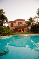 Luxury swimming pool and villa at dusk