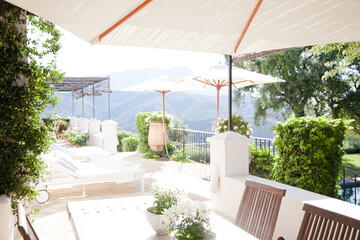 Lounge chairs and umbrellas on balcony of luxury hotel
