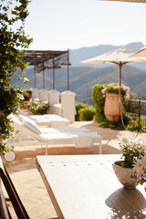 Lounge chairs and umbrellas on balcony of luxury hotel