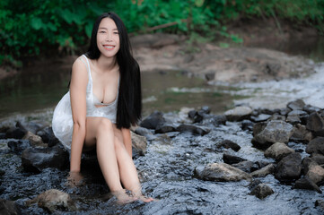 Portrait of sexy asian woman at the waterfall,Feeling fresh at the river,Thai female relax at country
