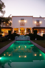 Fototapeta na wymiar Luxury swimming pool and villa illuminated at night