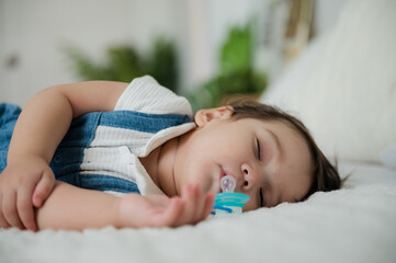 Cute little baby resting and sleeping with comfort at home on white bed