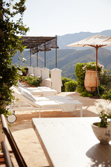 Lounge chairs and umbrellas on balcony of luxury hotel