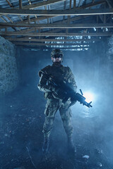 Fototapeta premium Portrait of airsoft player in professional equipment with machine gun in abandoned ruined building. Soldier with weapons at war