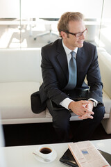 Businessman sitting on sofa in office lobby