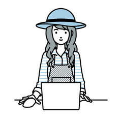 デスクで座ってPCを使っている農家の女性