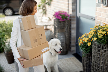 Woman with parcels and dog on the porch of her house
