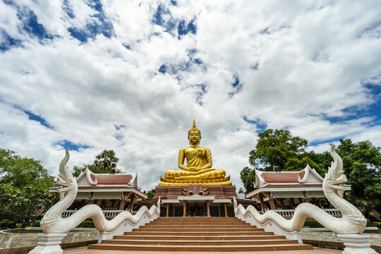 Beautiful Big Golden Buddha statue under blue sky background, khueang nai District, Ubon Ratchathani province, Thailand.